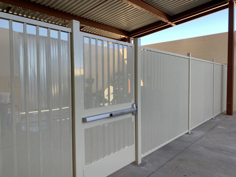 A white commercial wrought iron fence with a gate