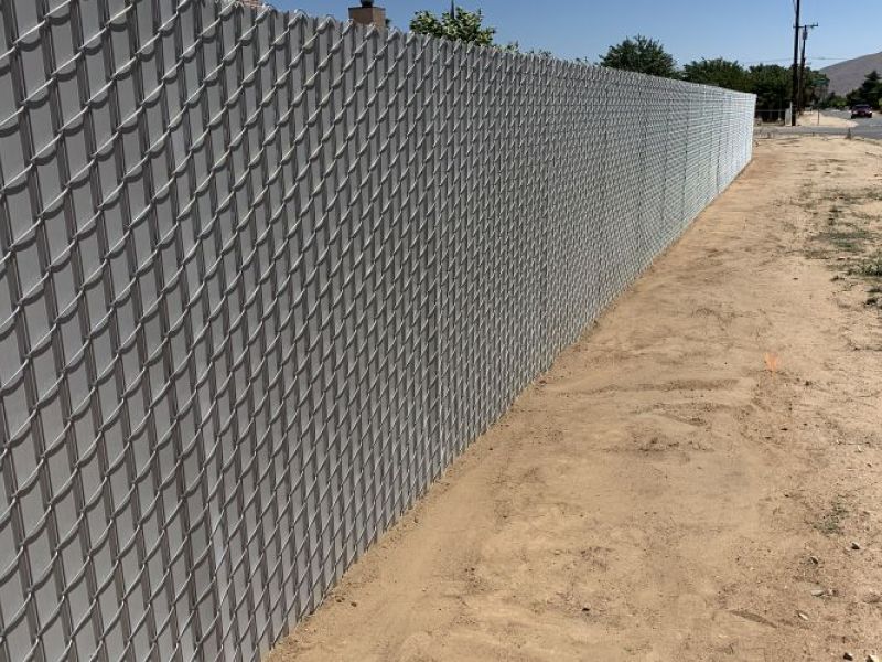 Grey privacy chain link fence surrounding a yard