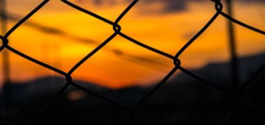 photo of sunset with chain link fence