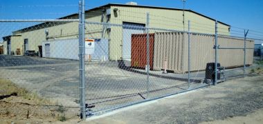  A large warehouse behind a security chain link fence