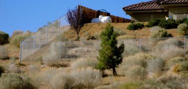 desert house surrounded by a chain link fence