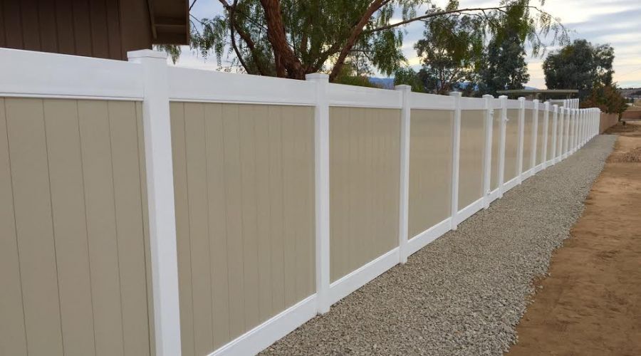 A white & brown privacy vinyl fence protecting a private property